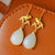 Orecchini in stile cinese con pendente dorato con gazza e giada