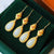 Ruota della preghiera dorata e orecchini in stile cinese in giada bianca